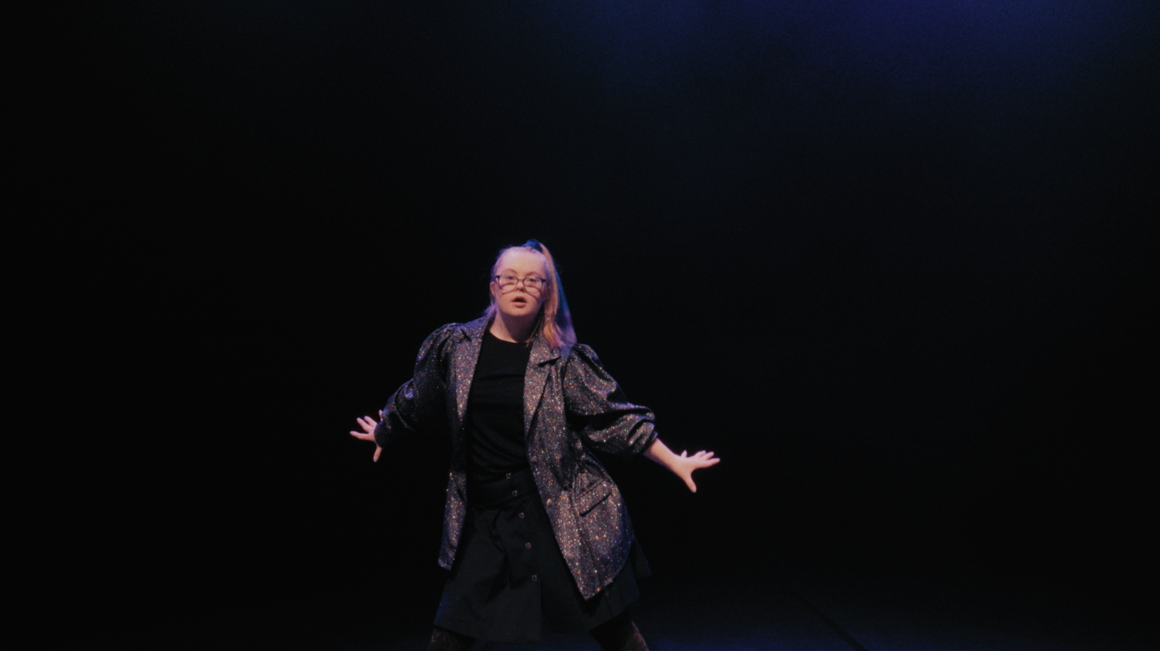 En dansare i ett mörkt scenrum