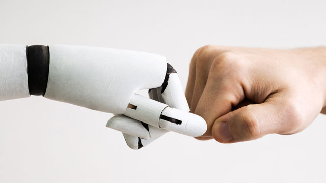 Bild på robothand som gör en "fistbump" med en människohand